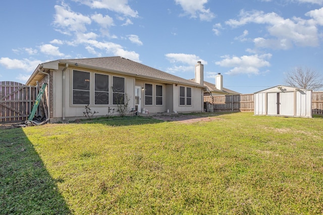 rear view of property featuring an outbuilding, a fenced backyard, a chimney, a storage unit, and a lawn