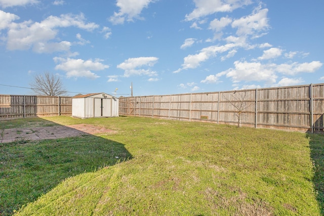 view of yard featuring an outdoor structure, a fenced backyard, and a shed