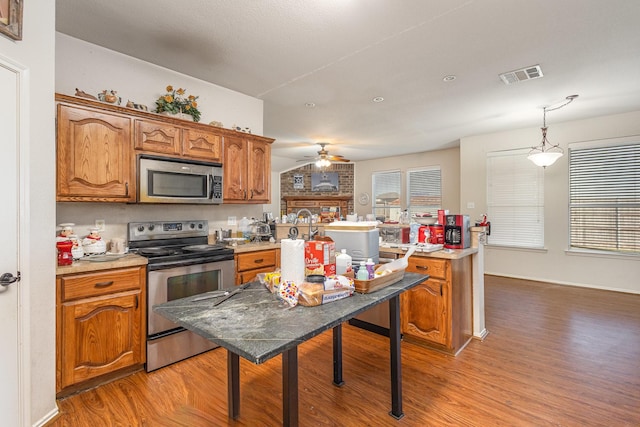 kitchen featuring brown cabinets, light wood-style floors, visible vents, and stainless steel appliances