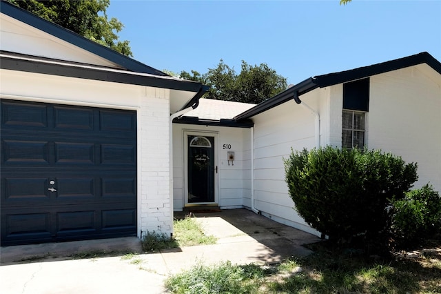 entrance to property featuring brick siding and an attached garage