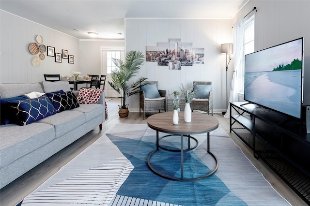 living room with visible vents, a healthy amount of sunlight, baseboards, and wood finished floors