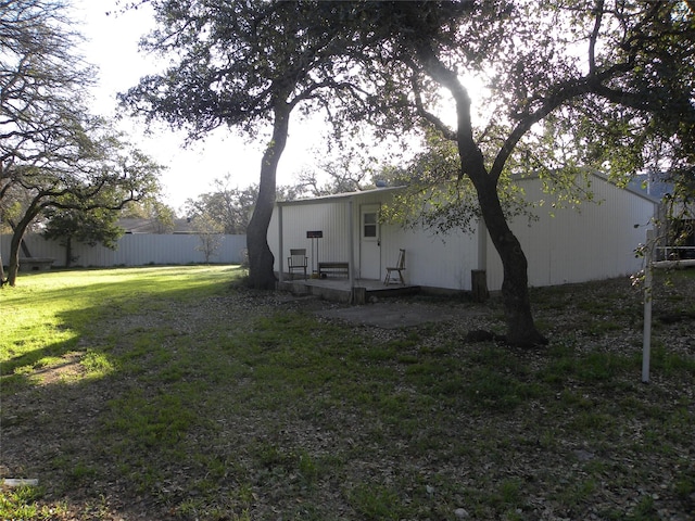 rear view of house with a lawn and fence