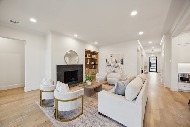 living room with light wood-style floors, recessed lighting, and visible vents