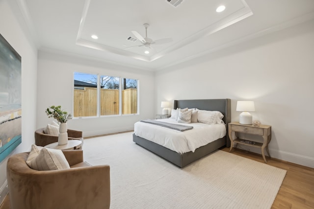 bedroom featuring baseboards, a tray ceiling, recessed lighting, wood finished floors, and a ceiling fan