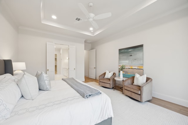 bedroom with visible vents, a raised ceiling, recessed lighting, light wood finished floors, and baseboards