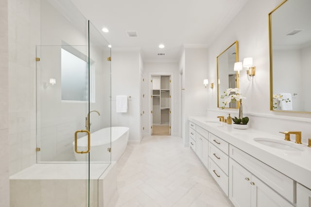 bathroom with a shower stall, a freestanding tub, crown molding, and a sink