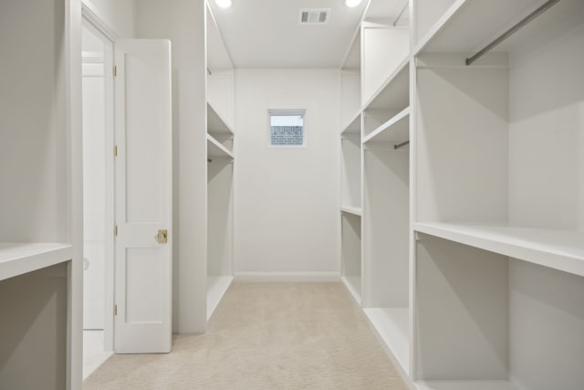 walk in closet with visible vents and light colored carpet