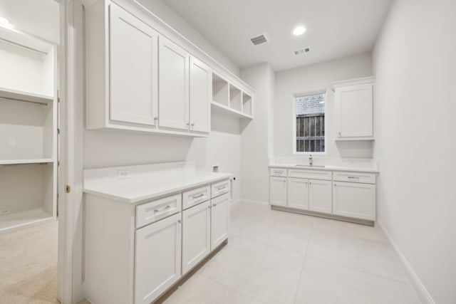 kitchen with visible vents, white cabinets, baseboards, and open shelves