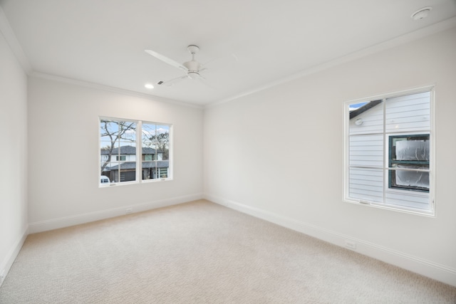 empty room featuring ornamental molding, baseboards, and light carpet