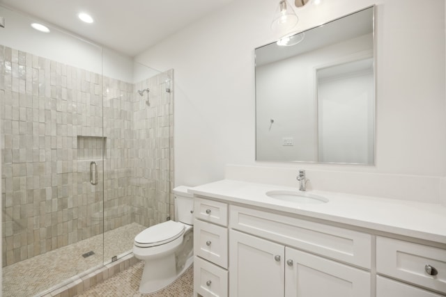 bathroom featuring recessed lighting, vanity, toilet, and a shower stall