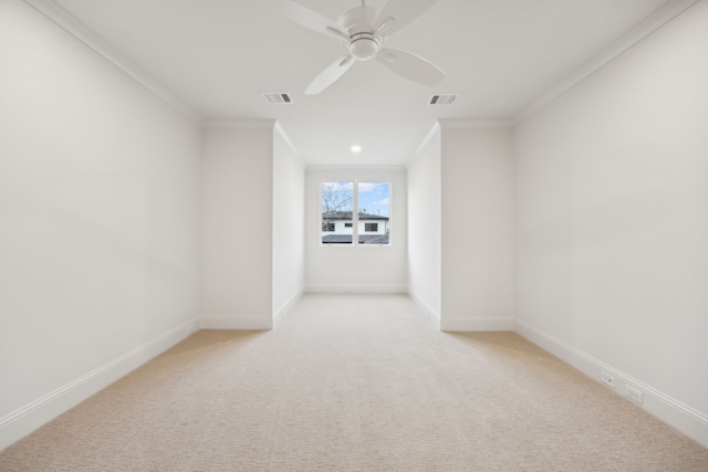 empty room with baseboards, light carpet, and crown molding