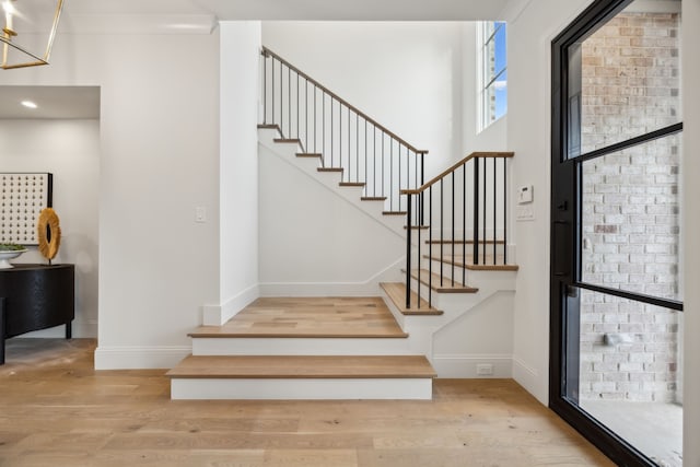 entrance foyer with stairway, baseboards, and wood finished floors