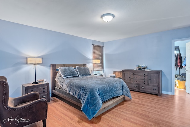 bedroom with light wood-type flooring and baseboards