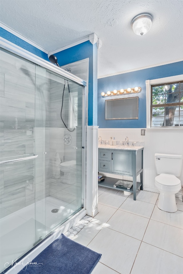 bathroom with crown molding, toilet, a stall shower, a textured ceiling, and vanity