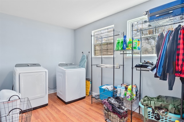 washroom featuring laundry area, light wood-style floors, and washing machine and clothes dryer