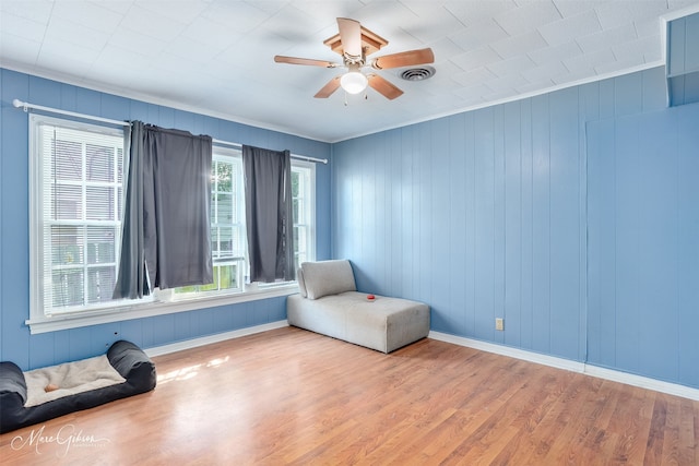 unfurnished room with ceiling fan, baseboards, wood finished floors, and crown molding