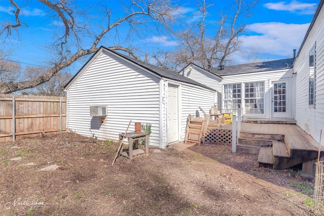 exterior space with a wall mounted AC and fence