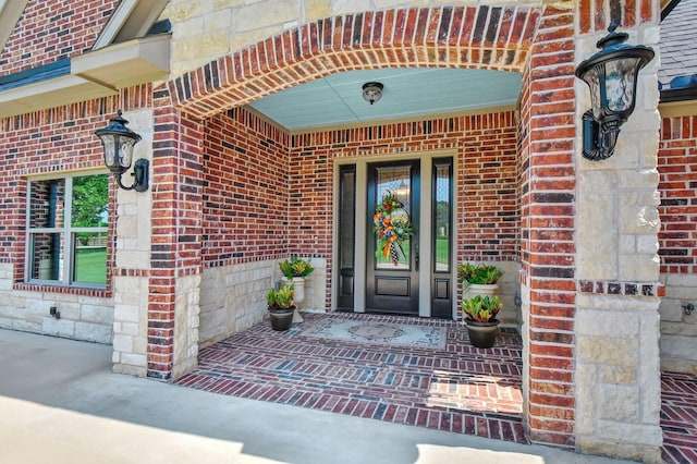 entrance to property featuring brick siding and stone siding