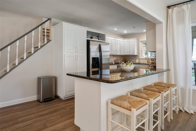 kitchen with dark wood-style flooring, white cabinets, and stainless steel fridge with ice dispenser