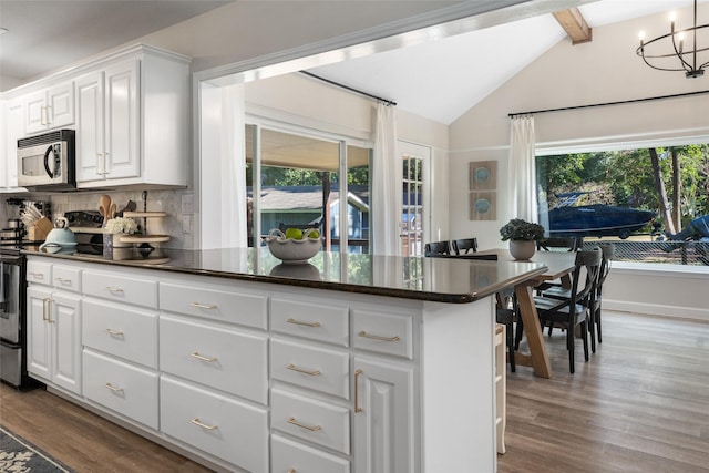 kitchen with lofted ceiling with beams, wood finished floors, tasteful backsplash, and stainless steel appliances