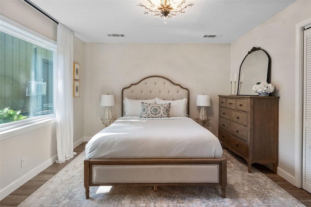 bedroom featuring visible vents, baseboards, and wood finished floors