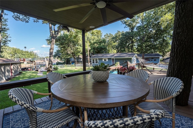 wooden deck with ceiling fan, a yard, and outdoor dining space