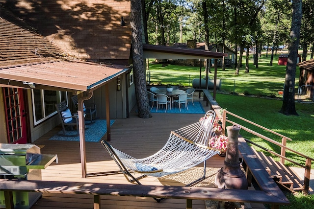 wooden deck with a lawn and outdoor dining space