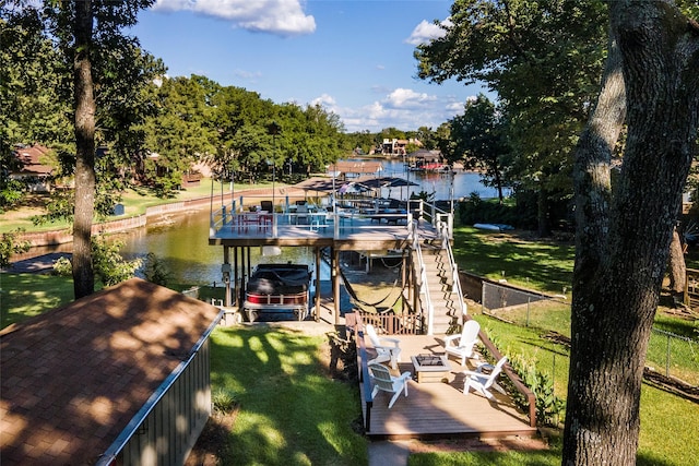 dock area featuring a yard, fence, a water view, and boat lift