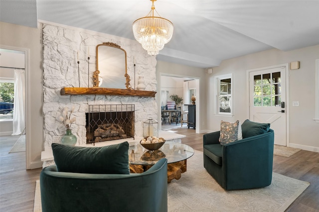 living room featuring plenty of natural light, a fireplace, baseboards, and wood finished floors