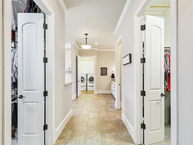 hall featuring washing machine and dryer, crown molding, and baseboards