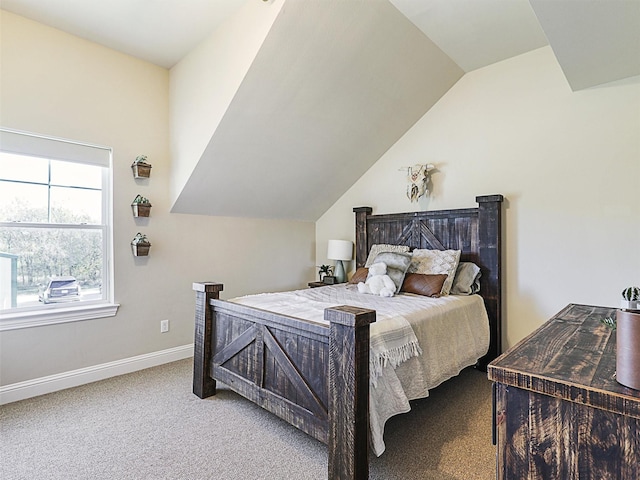 bedroom with baseboards, lofted ceiling, and carpet flooring