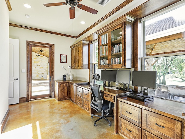 office area featuring visible vents, crown molding, baseboards, concrete flooring, and built in desk