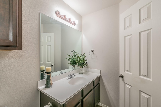 bathroom with vanity and a textured wall