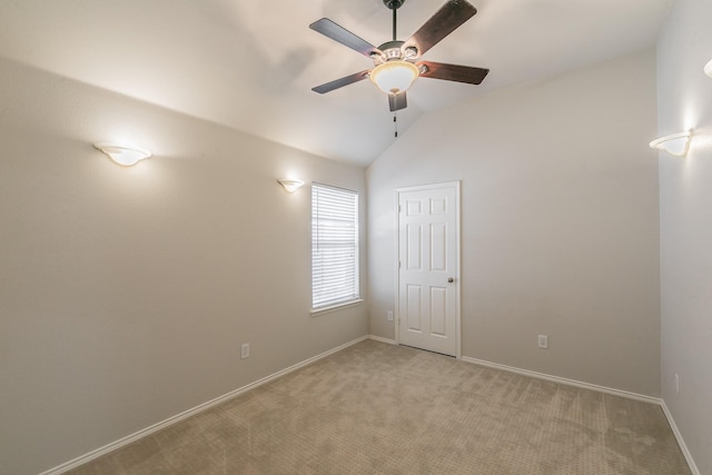 unfurnished room featuring baseboards, light colored carpet, a ceiling fan, and vaulted ceiling