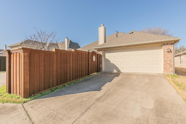 view of home's exterior with fence, roof with shingles, a chimney, concrete driveway, and brick siding