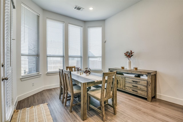 dining space with light wood-style flooring, baseboards, and visible vents