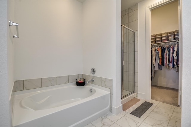 full bathroom with a garden tub, marble finish floor, a shower stall, baseboards, and a spacious closet