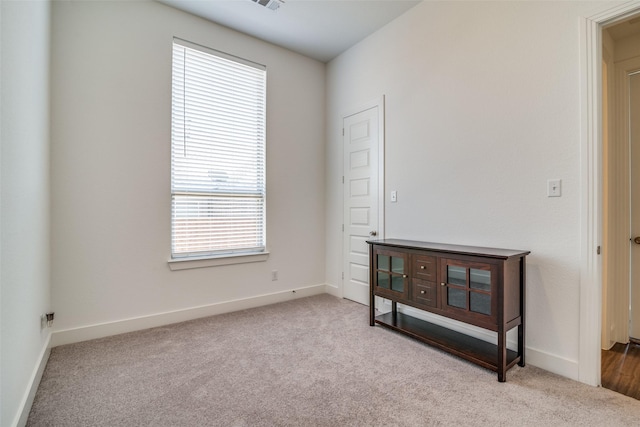 empty room featuring visible vents, baseboards, and carpet flooring