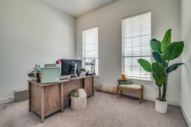 office space featuring light carpet and baseboards