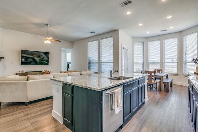 kitchen featuring visible vents, light wood-style flooring, dishwasher, and a sink