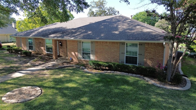 single story home with a front lawn, brick siding, and a shingled roof