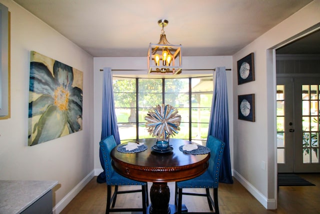 dining room featuring wood finished floors, french doors, baseboards, and a chandelier