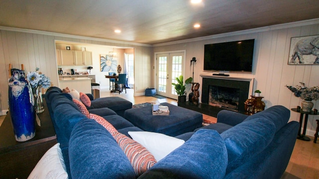 living room featuring light wood-style flooring, a fireplace, and ornamental molding