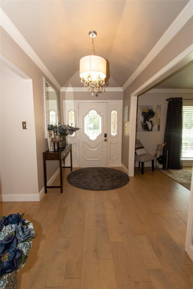 foyer entrance with a notable chandelier, crown molding, light wood-type flooring, and lofted ceiling