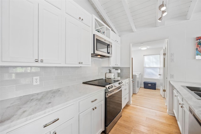 kitchen with decorative backsplash, light wood-style floors, white cabinetry, and stainless steel appliances