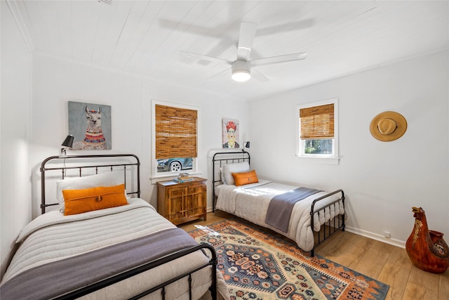 bedroom with baseboards, a ceiling fan, and hardwood / wood-style flooring