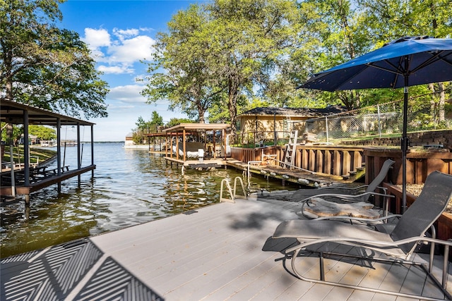 view of dock with boat lift, fence, and a water view