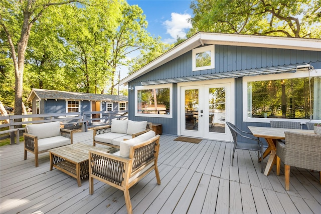 wooden deck featuring an outbuilding, an outdoor hangout area, outdoor dining area, and french doors