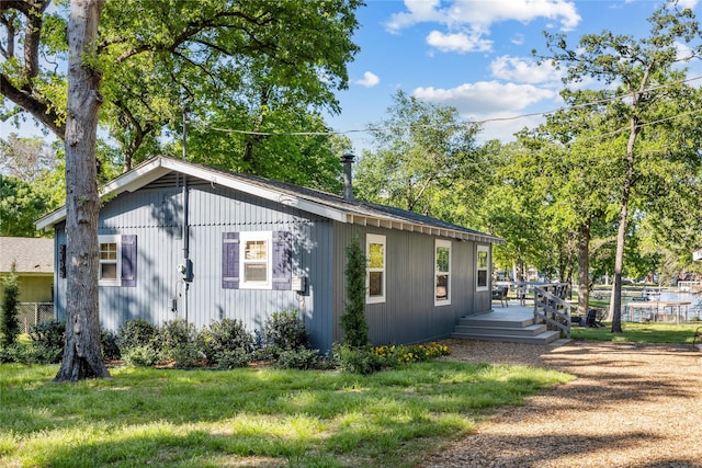 view of home's exterior featuring a wooden deck and a lawn