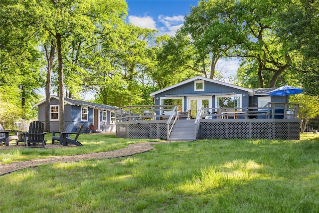 rear view of property with a lawn and a wooden deck